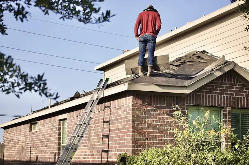 Professional roofer working on a residential roof in Rainsville